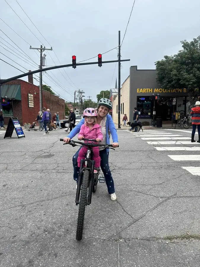 Sarah and her daughter Em on a bike in downtown Brevard